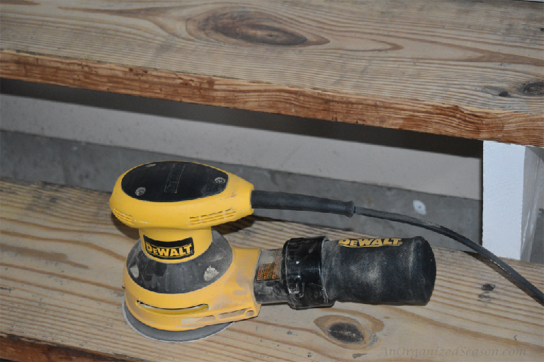 Use a hand sander on stair treads to update your garage entryway.