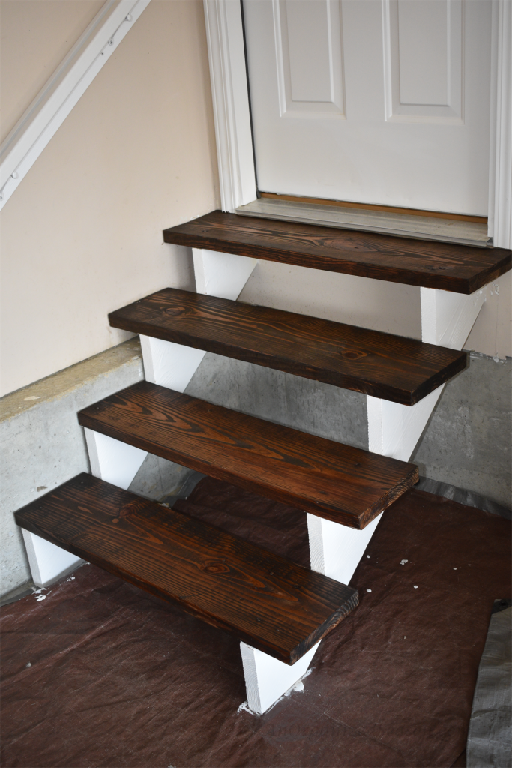 Stairs with stained treads and white risers, an example of how to update your garage entryway.