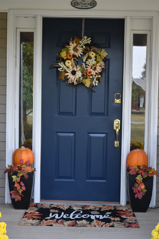 Beautiful wreath and fall themed rug to spruce up front door