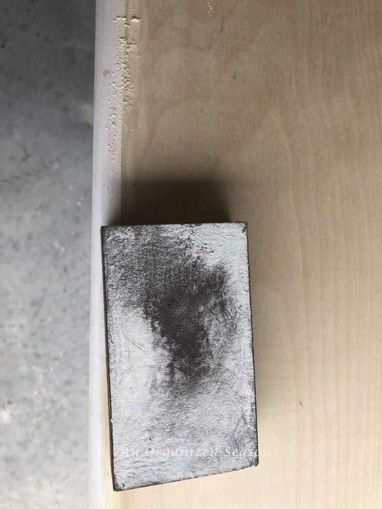 A sanding block used to remove excess wood filler from seam.