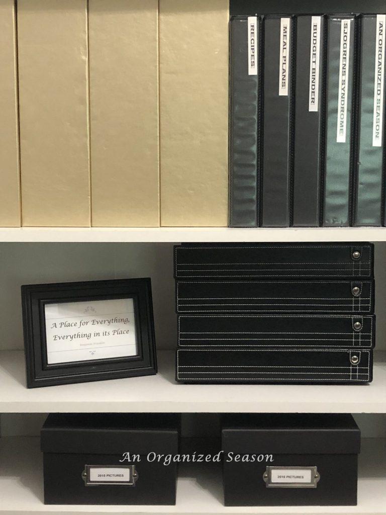 Magazine boxes, binders, stackable paper trays and picture boxes on a white shelf 