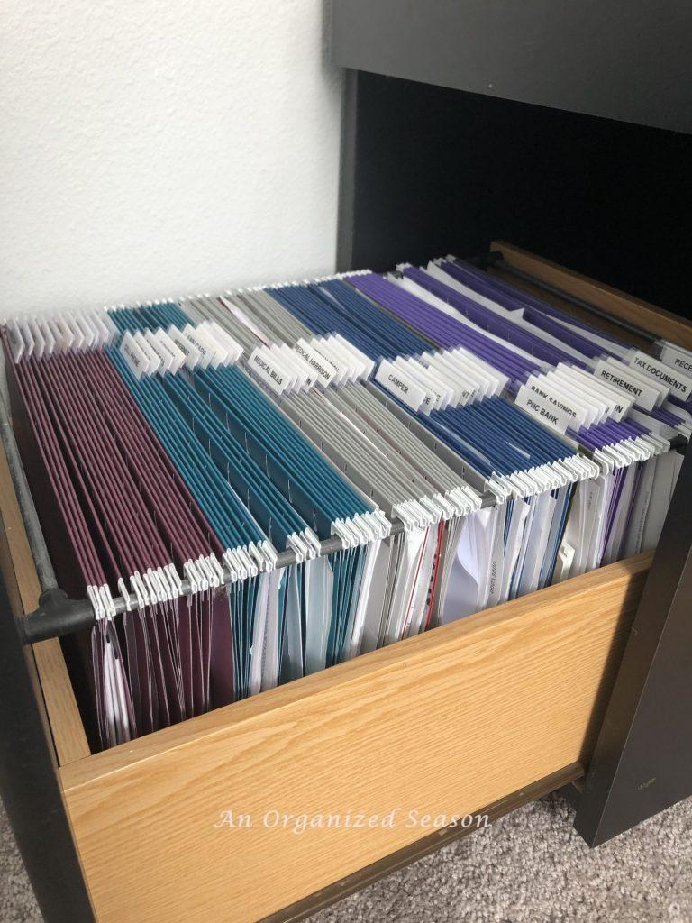 File cabinet with five different colors of file folders to organize paper clutter