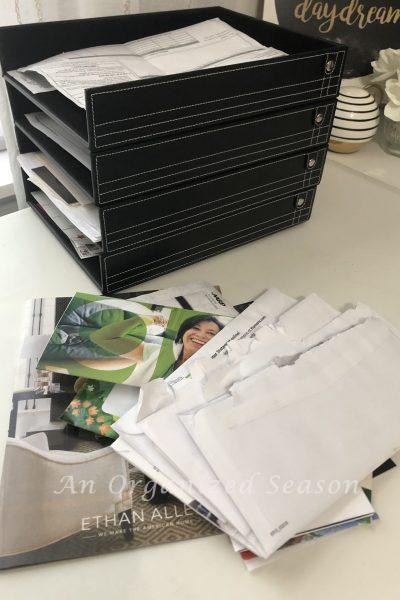 Pile of paper clutter that needs to be organized in the stackable paper trays