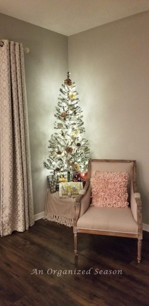 Small Christmas tree decorated for valentines day with Christmas presents underneath.