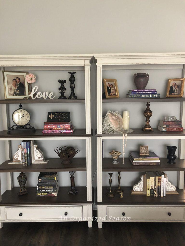 Styled bookshelves with Valentines decorations mixed in with books, clock and candleholders. 