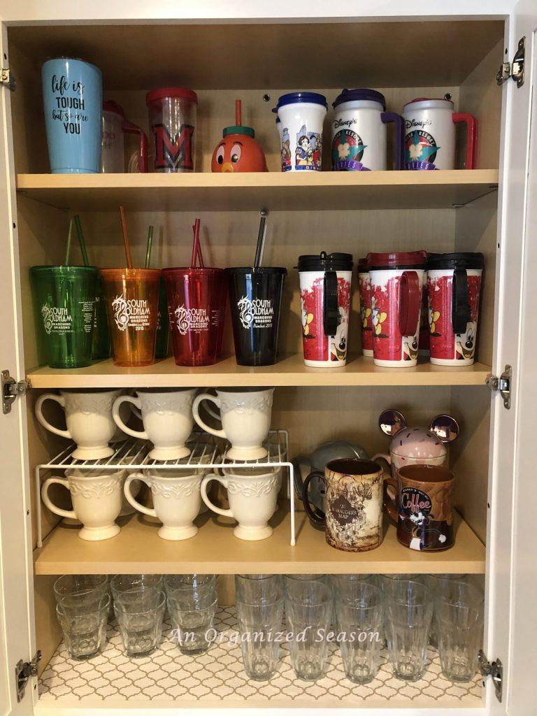 Cabinet with four shelves of organized drinking glasses.