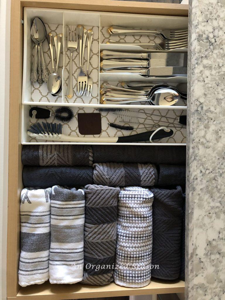 cutlery organizer and dish towels that have been rolled instead of being folded, Showing how I organized my kitchen using zones.