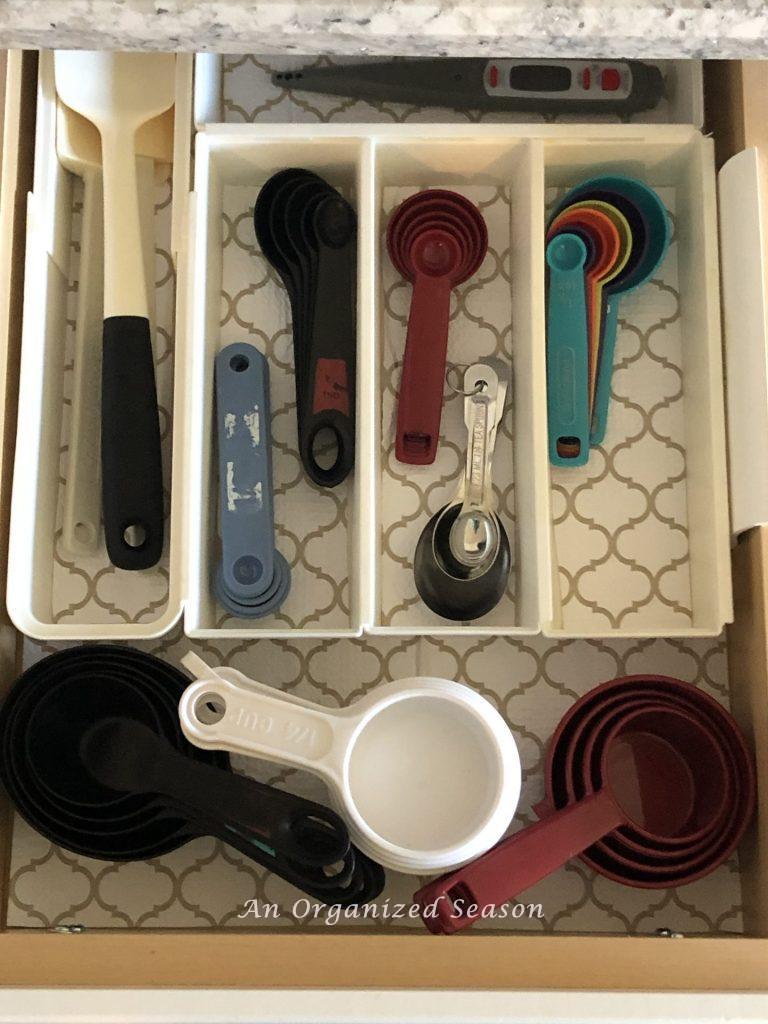 A drawer with separated spaces for measuring cups and spoons.