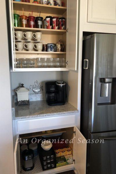 Upper and lower kitchen cabinets that are organized with items for drinking beverages. showing an example of how I organize my kitchen using zones.