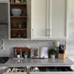 An organized kitchen with an open cabinet and two drawers.