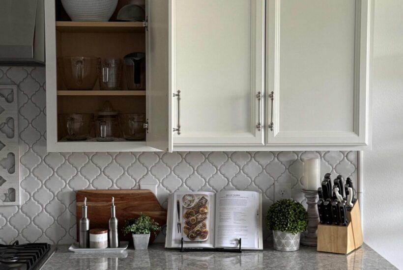 An organized kitchen with an open cabinet and two drawers.
