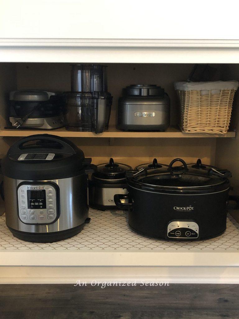 Cabinet showing containing small kitchen appliances showing how I organized my kitchen using zones.