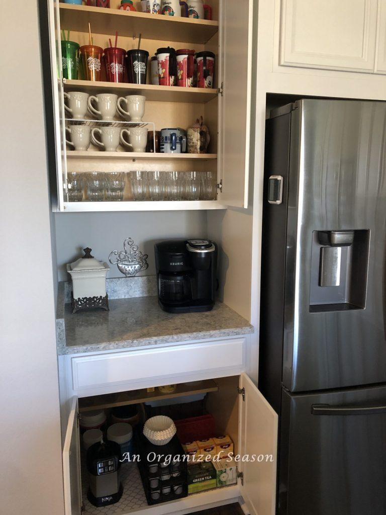 Upper and lower kitchen cabinets with cups and beverages showing how I organized my kitchen using zones. 