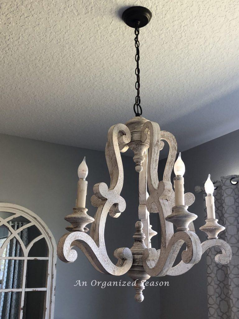 French country style chandelier hanging above table completing step two in my eat-in kitchen makeover