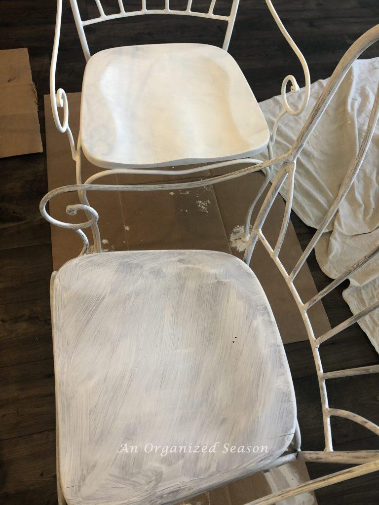 Chairs in different stages of being painted white. 
