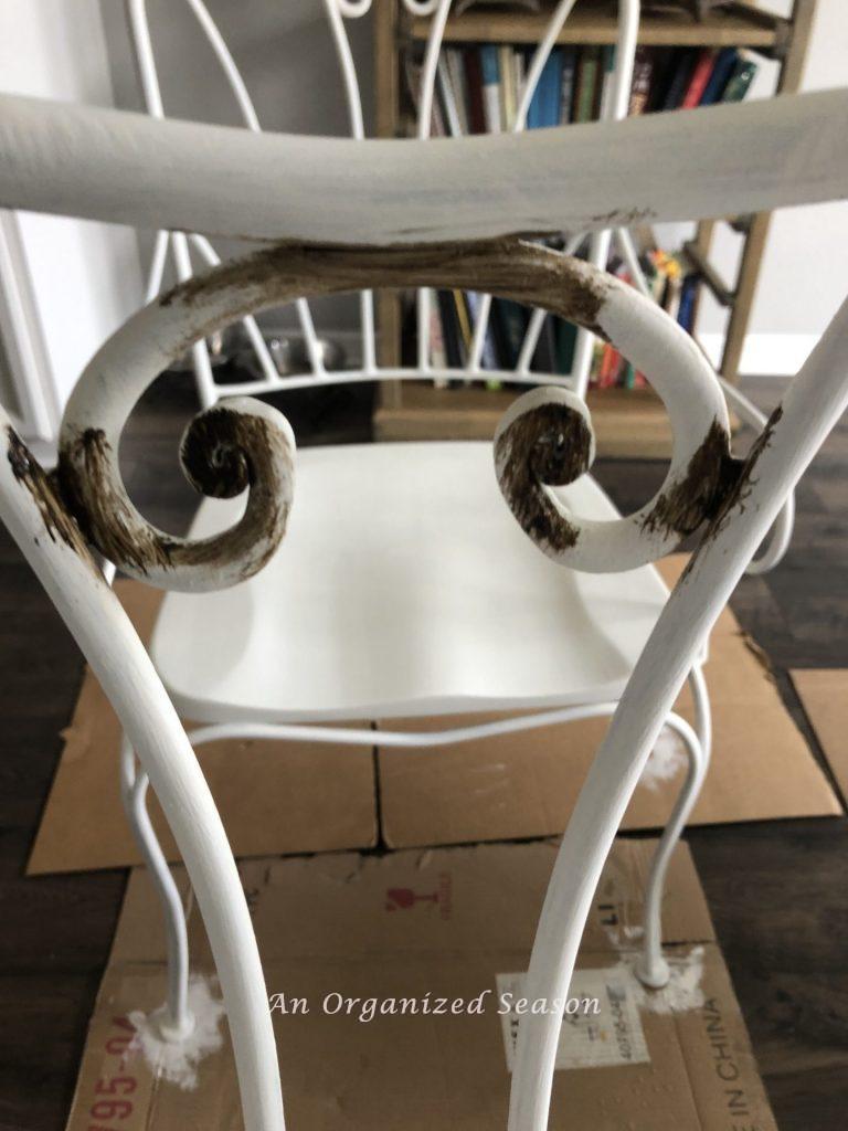 White chair with brown antiquing wax on it. 