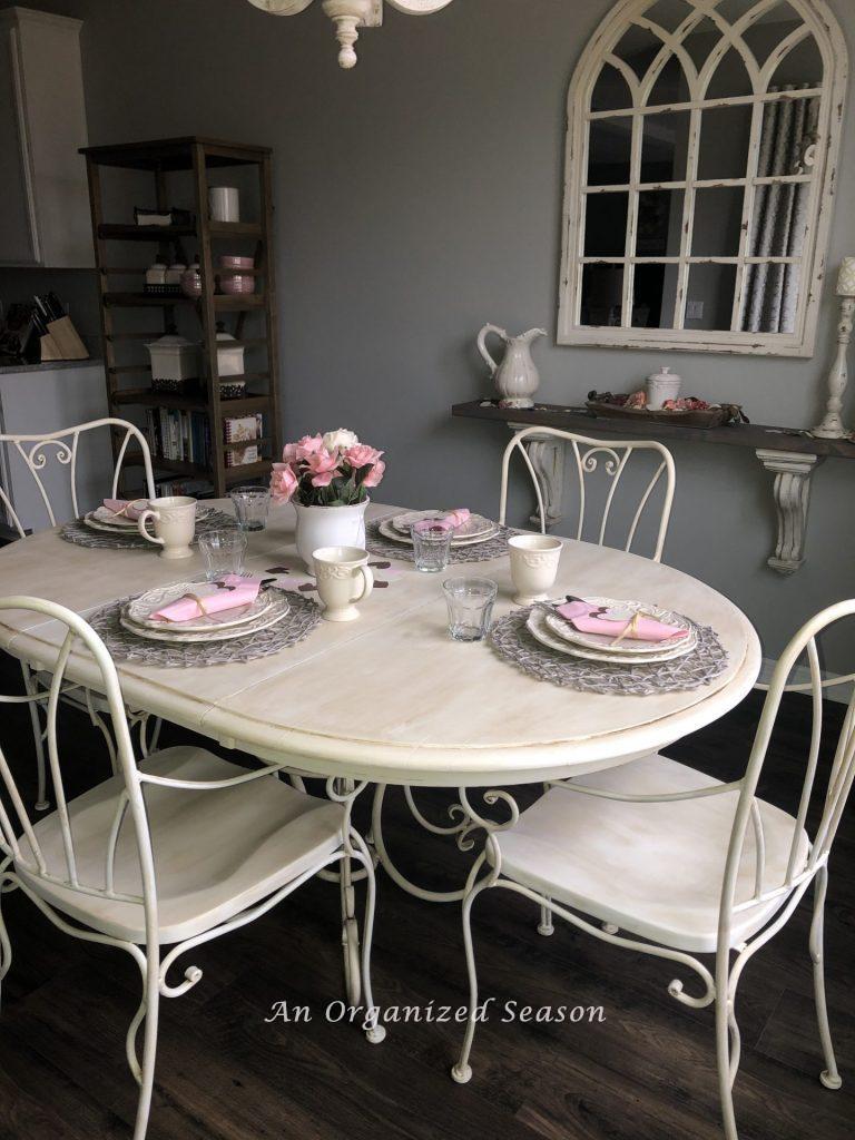 kitchen table and chairs painted with white chalk paint and antiqued with brown wax completing step five in my eat-in kitchen makeover