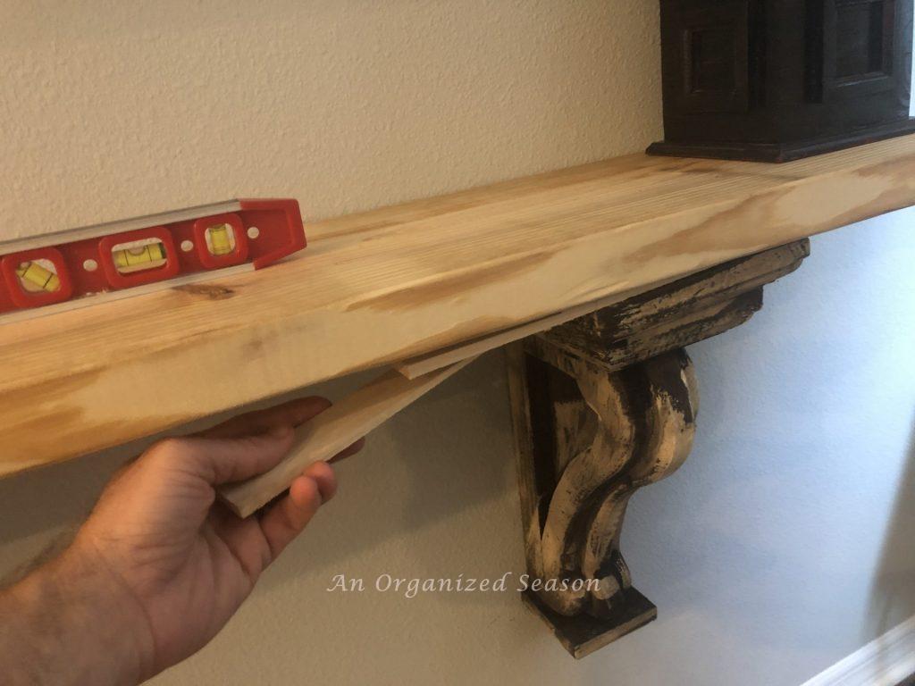 next step in how to build a shelf using corbels is to show how to level the shelf with shims