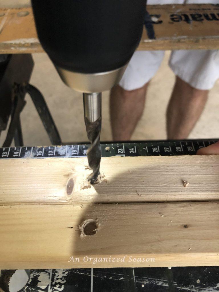 Drilling holes in the brackets showing how to build a personalized coat rack.