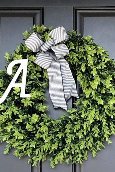 boxwood wreath with a striped black and white bow and the letter A