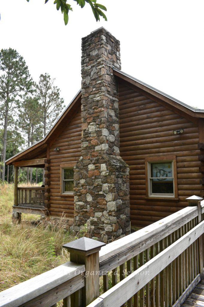 A log cabin with stone fireplace and covered porch. The museum at the Oakland Nature Preserve in central Florida.