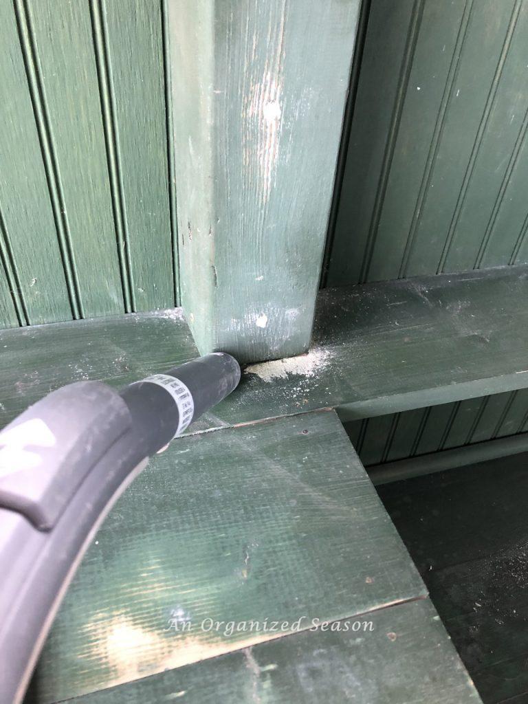 A vacuum cleaner sucking up dust after potting bench had been sanded.  Step four on how to give an old potting bench new life.