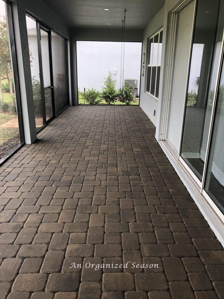 An empty screened in back porch. Showing step two for how to enjoy your porch this Spring.