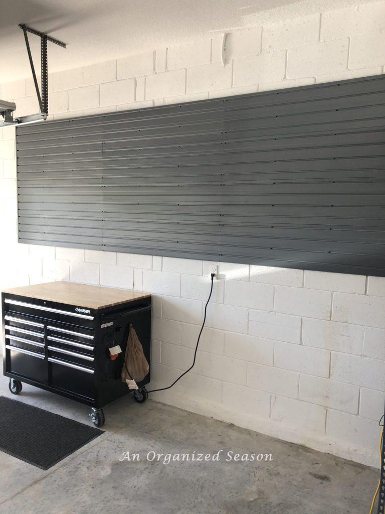 Silver Flow Wall panels attached to a white garage wall. Showing how to install a Flow Wall System.