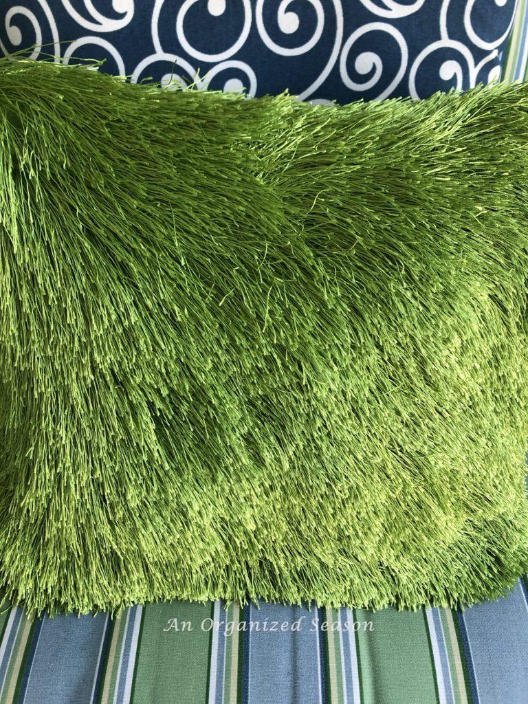 A green fringed pillow that reminds me of grass.  Adds texture and interest to help you enjoy your porch this Spring.