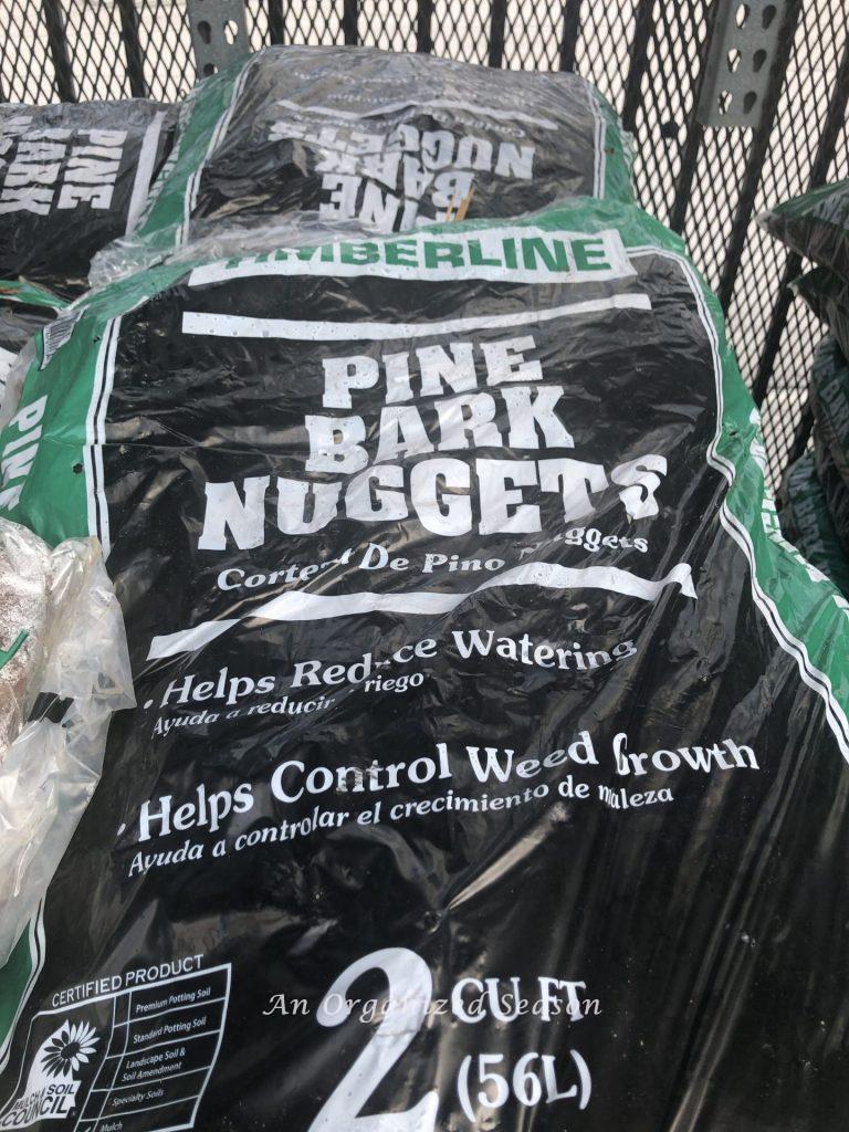Bags of pine bark nugget mulch piled on top of each other.  Mulch is one of several helpful tips to organize and spruce up your yard.