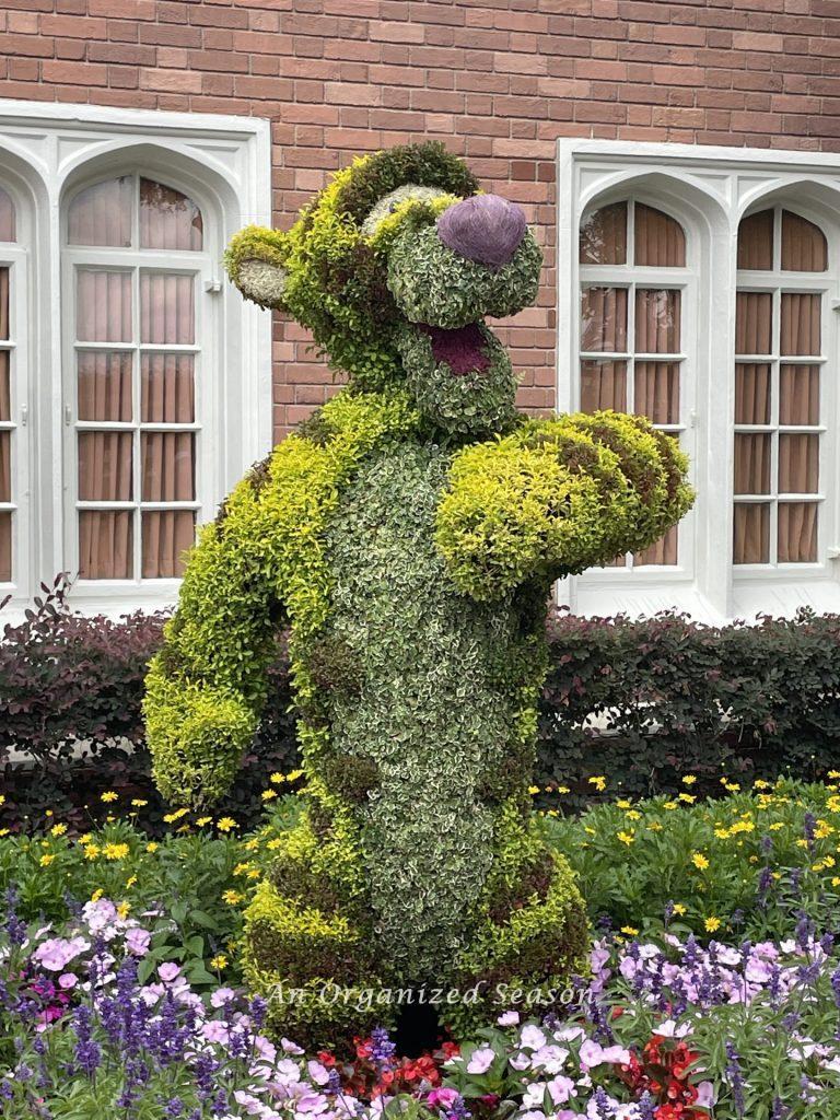 A topiary of the character Tigger standing in a garden at the United Kingdom pavilion. An example of what to do from the EPCOT Flower and Garden Festival guide.