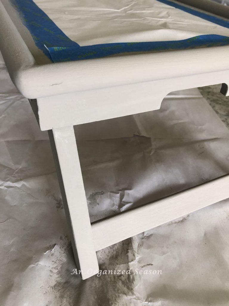 A tray that has been painted with gray paint sitting on a kitchen counter. Step six for how to makeover a breakfast in bed tray.