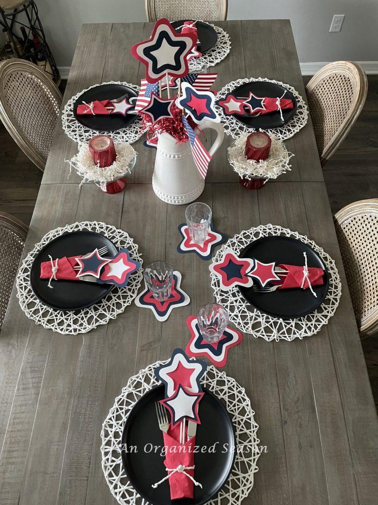 A dining room table with six place settings and a centerpiece.  Showing how to create a patriotic table for the 4th of July.