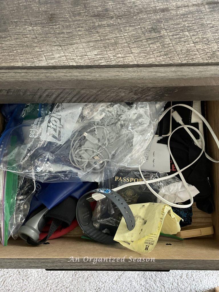 A disorganized drawer in a bedside table.