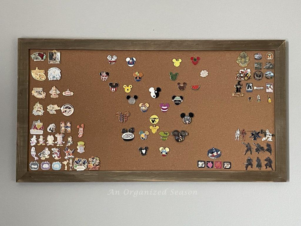 Disney pins displayed on a cork board. 