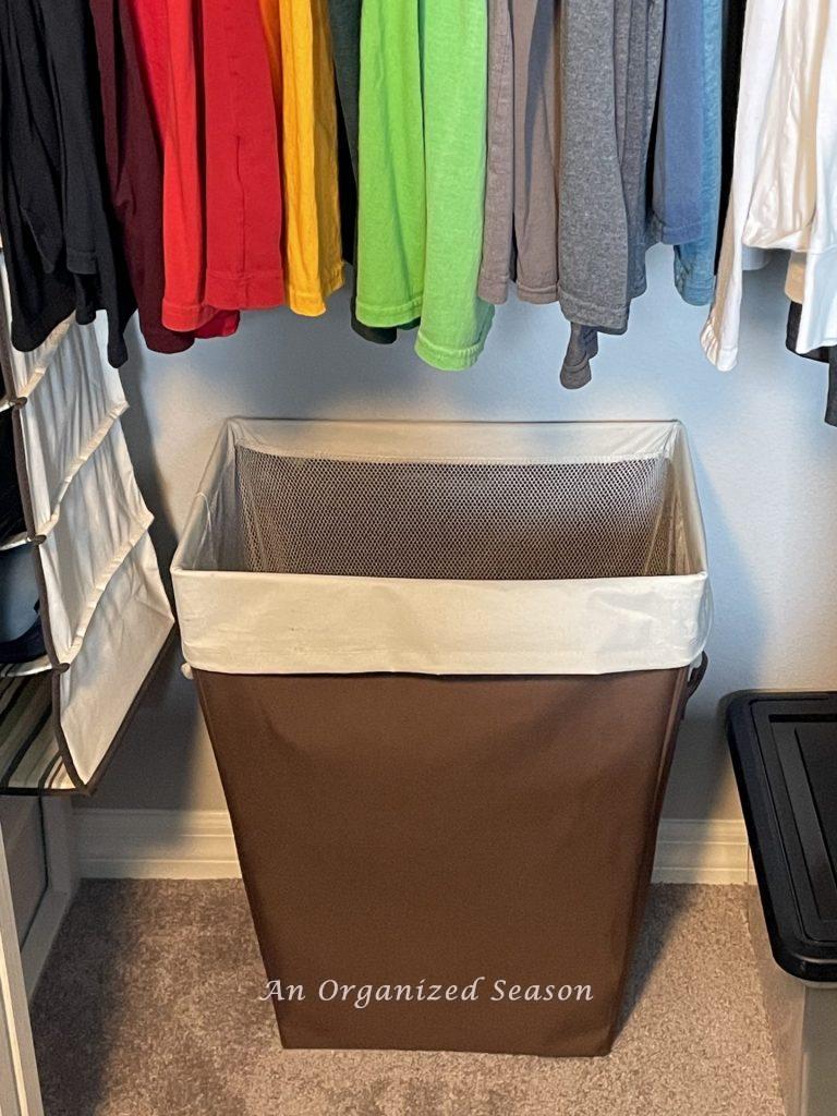 A laundry basket inside a closet. 