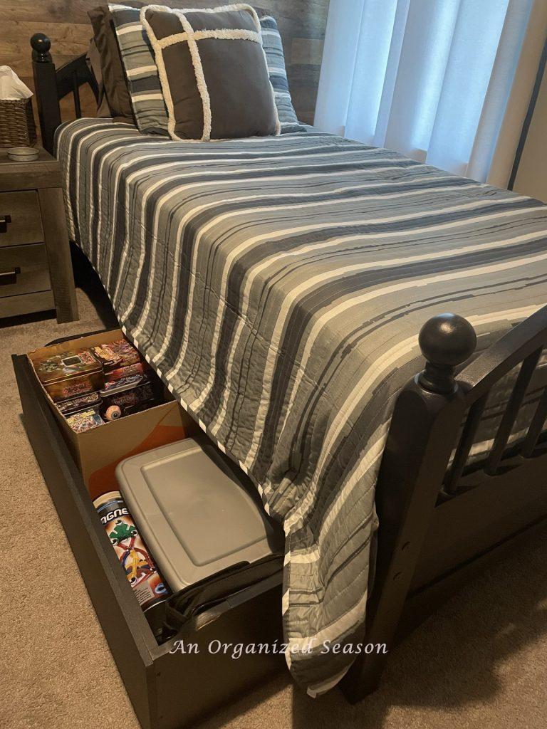 A twin bed with a storage drawer underneath it.