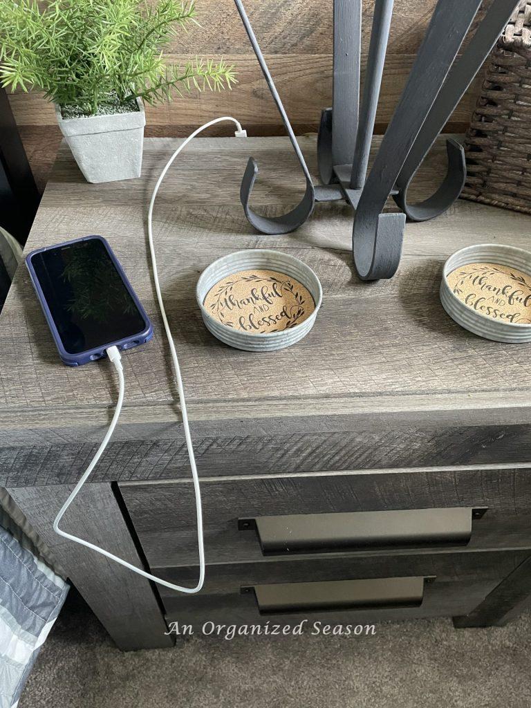A phone charging on a bedside table.