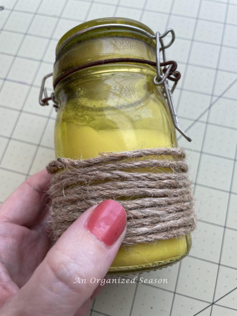 Wired jute cord wrapped around a glass candle. Step one for how to make two types of twine pumpkins.