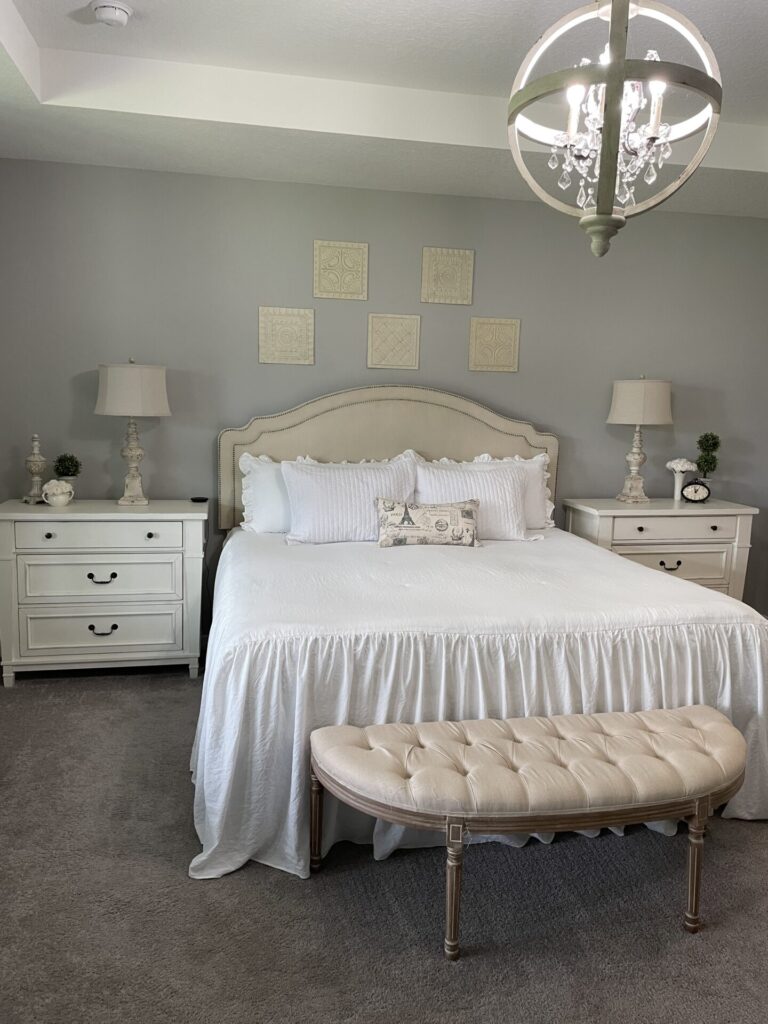 Master bedroom with gray walls and white  and cream accessories. 