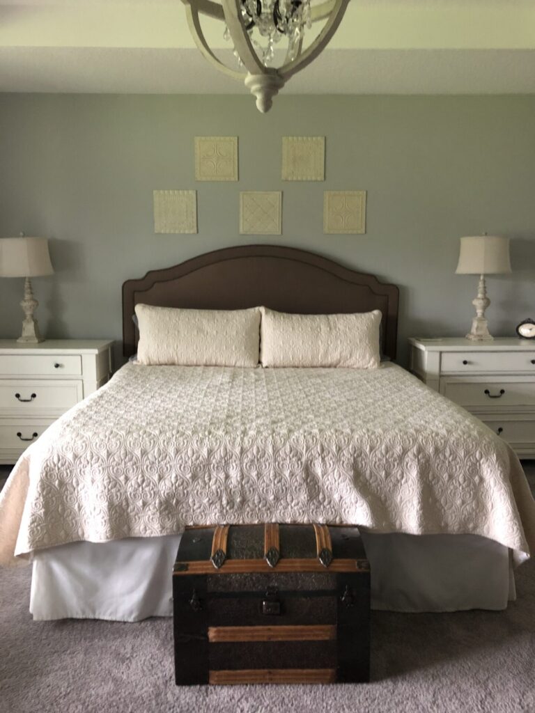 A bed with a green fabric headboard. 