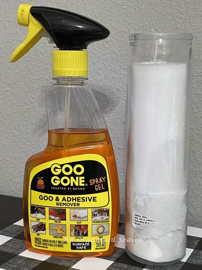 A bottle of Goo Gone sitting next to a candle with sticker residue. Step one for how to make a Rae Dunn inspired candle. 