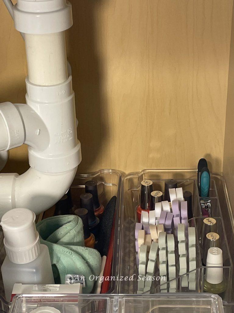 Items used for manicure and pedicure contained inside two clear plastic bins. Showing master bathroom organization ideas. 