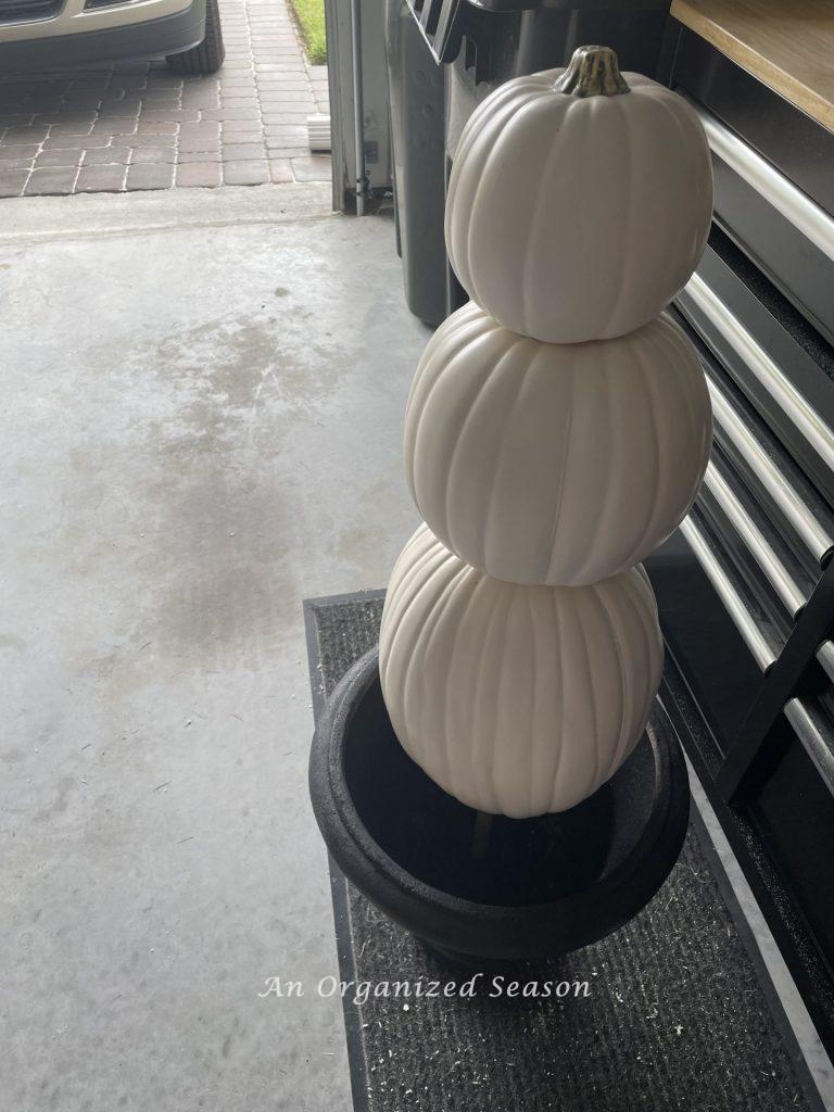 Place the three faux pumpkins on the dowel rod and insert into the hole in your planter. Step seven for how to make a pumpkin topiary.