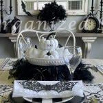 A kitchen table and shelf decorated for Halloween with black and white decor items.