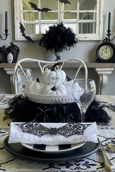 A kitchen table and shelf decorated for Halloween with black and white decor items.