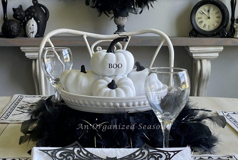 A kitchen table and shelf decorated for Halloween with black and white decor items.