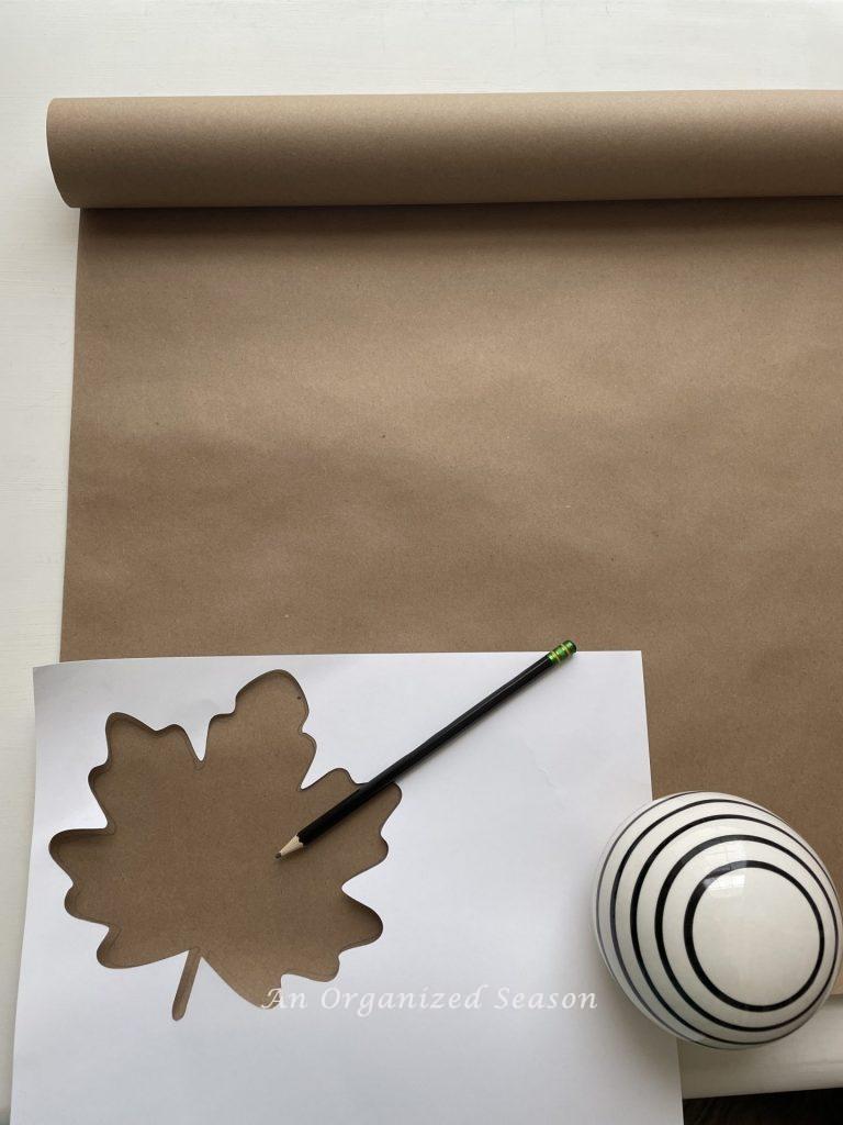 Step one to create a simple paper leaf garland is to trace the leaf on brown craft paper. 