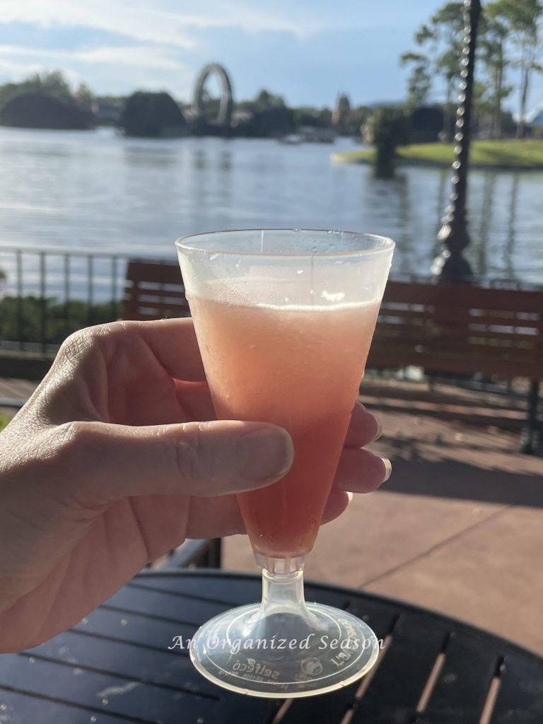 A woman holding a glass of frozen rose at the EPCOT food and wine Festival.