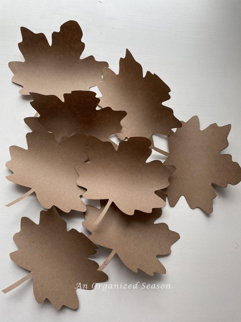 Maple leaves cut out of brown craft paper, a simple step to create a paper leaf garland.